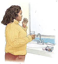 Γυναίκα στέκεται στο νεροχύτη μπάνιο λαμβάνοντας χάπι ελέγχου των γεννήσεων.