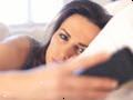 Δυσαρεστημένοι γυναίκα στο κρεβάτι κοιτάζοντας το κινητό τηλέφωνο της