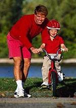 Εικόνα ενός πατέρα διδάσκει το νεαρό γιο του πώς να οδηγούν ένα ποδήλατο